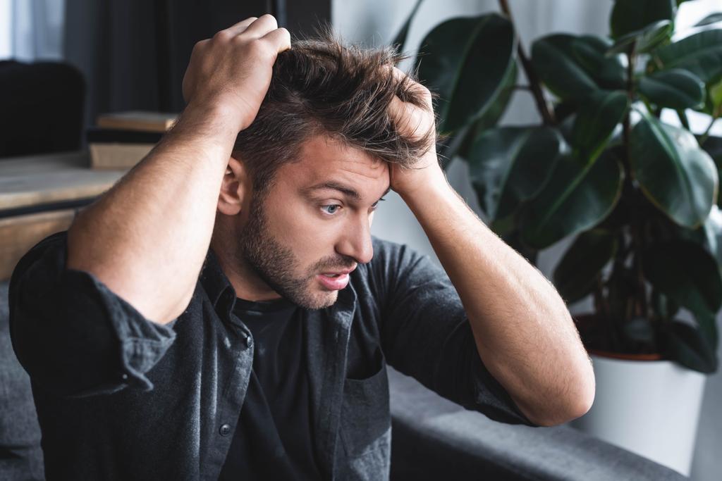 handsome man with panic attack touching head in apartment  - Photo, Image