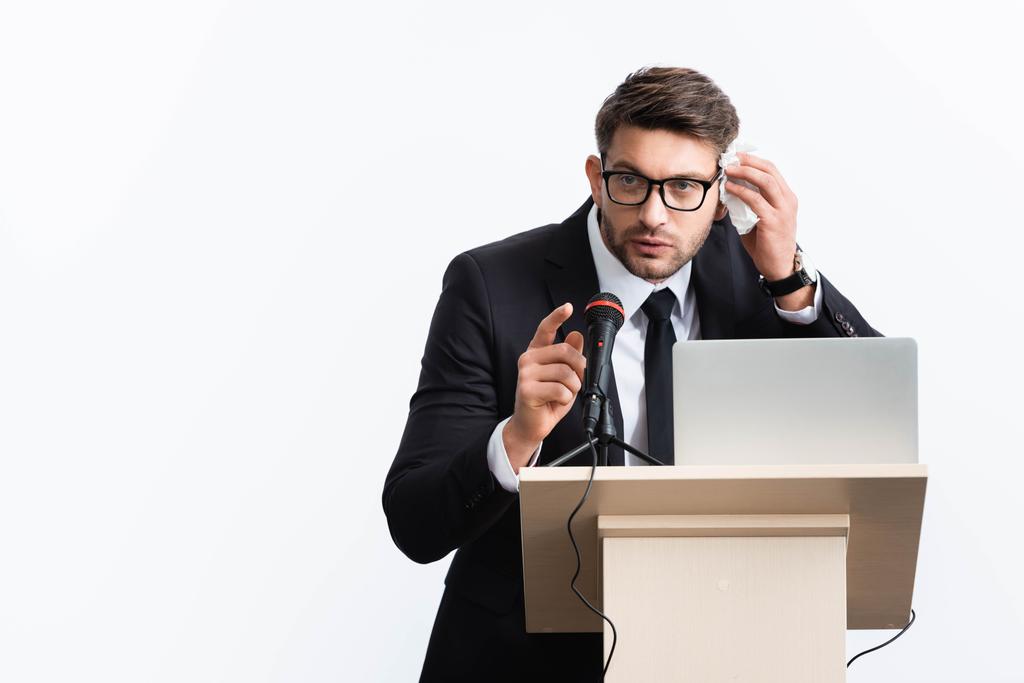 hombre de negocios asustado en traje parado en tribuna del podio y hablando durante conferencia aislado en blanco
  - Foto, imagen