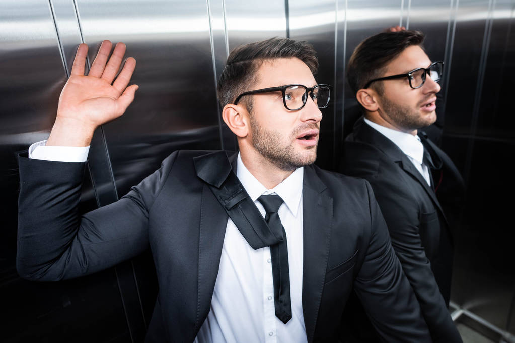 homme d'affaires beau et effrayé en costume avec claustrophobie dans l'ascenseur
 - Photo, image
