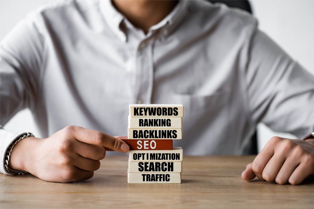 cropped view of seo manager holding wooden rectangle with seo illustration  - Photo, Image