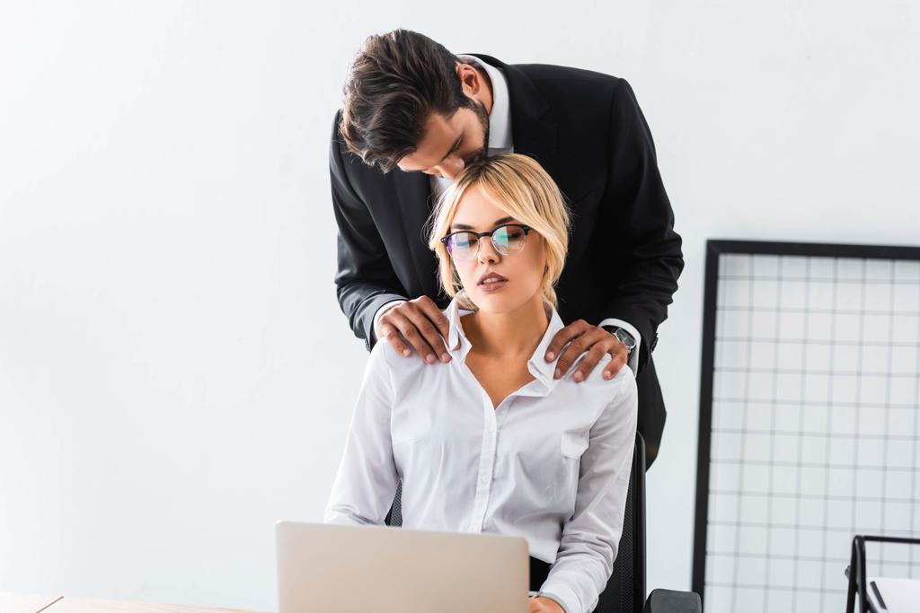 Empresário beijando colega com laptop no escritório
 - Foto, Imagem