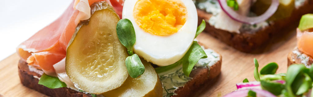 panoraamakuva kinkkua, suolakurkkua ja puolet keitettyä munaa tanskalaisella smorrebrodilla
  - Valokuva, kuva