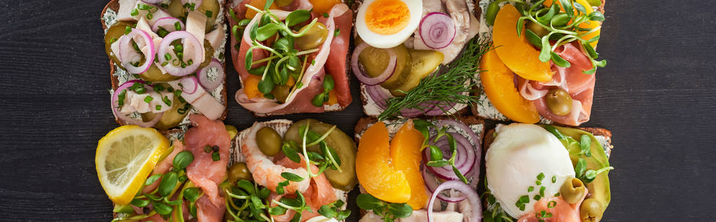 панорамный снимок традиционных сморребровых бутербродов на серой поверхности
  - Фото, изображение