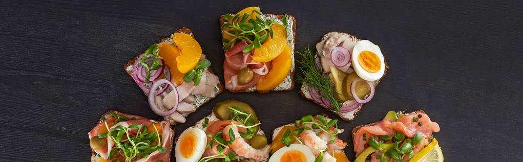 панорамний знімок житнього хліба з бутербродами на сірому
  - Фото, зображення