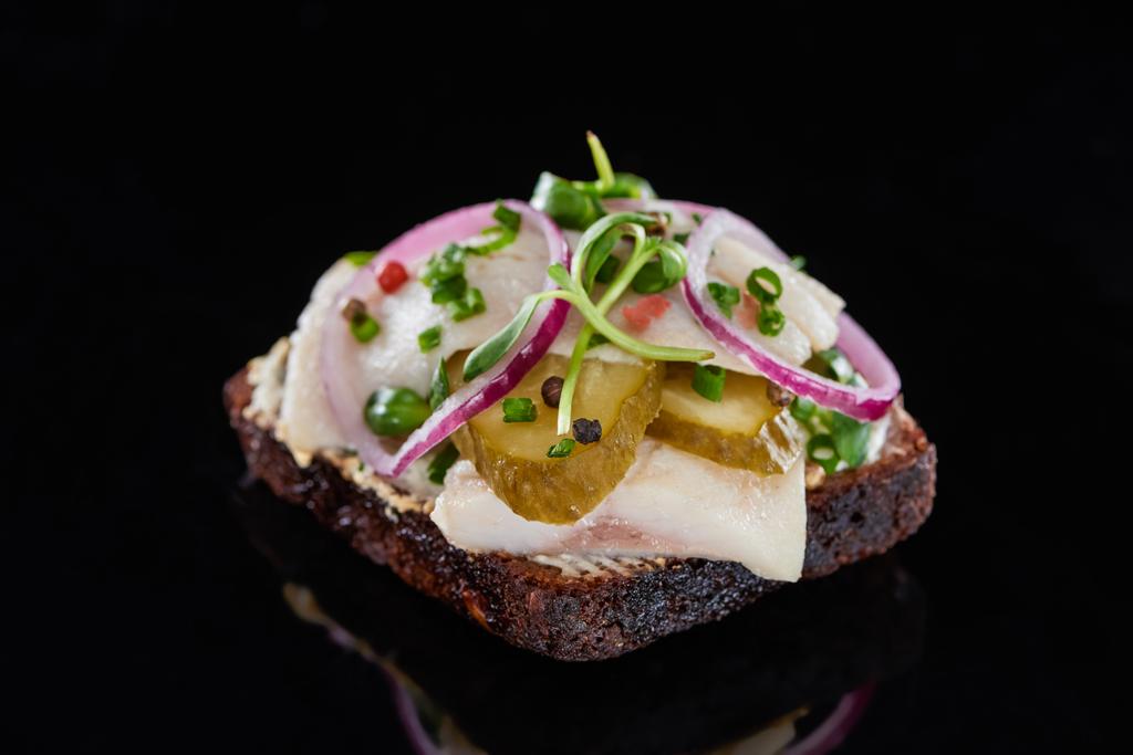 close-up de peixe de arenque em dinamarquês smorrebrod sanduíche em preto
  - Foto, Imagem