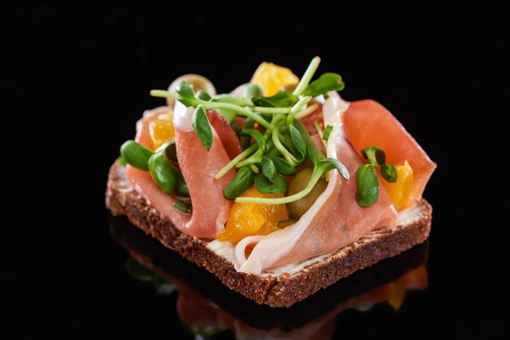 close-up van ham op gekookte Deense smorrebrod sandwich op zwart  - Foto, afbeelding