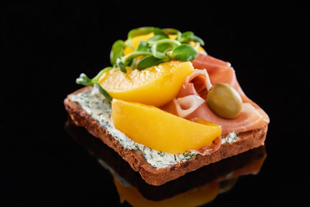 selective focus of ham and canned peaches on danish smorrebrod sandwich on black  - Photo, Image