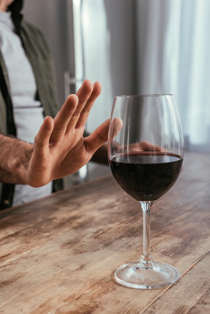 Обрезанный вид алкоголика, дергающего руку за бокал вина
 - Фото, изображение