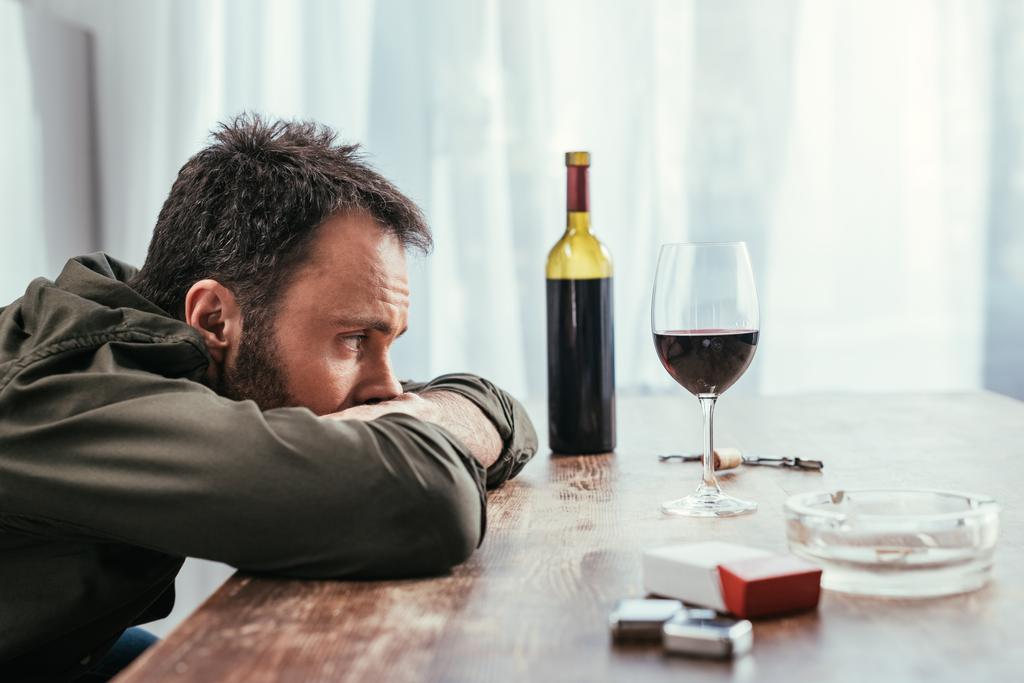 Вибірковий фокус алкоголю залежить від людини, яка дивиться на келих вина на столі
 - Фото, зображення