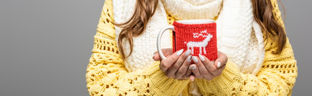 cropped view of girl in yellow sweater, scarf holding mug of cocoa isolated on grey, panoramic shot - Photo, Image