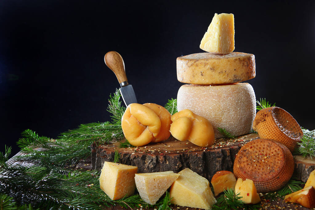 自家製チーズの大規模な品揃えのまだ生活。クラフトチーズを作るチーズの中には特別なナイフが刺さっています。まだ人生の概念。スペースのコピー. - 写真・画像