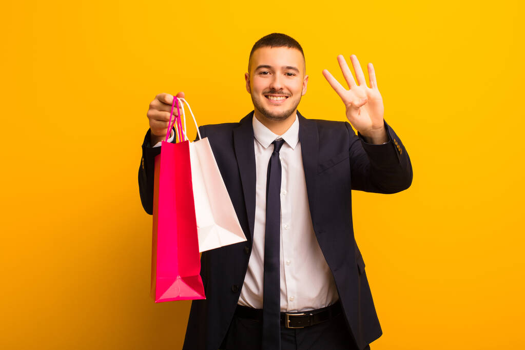 fiatal jóképű üzletember ellen lapos háttér bevásárló táskák - Fotó, kép