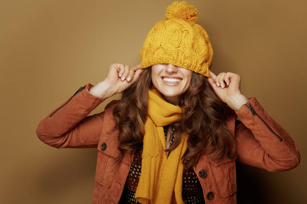happy woman with beret over eyes against beige background - Photo, Image