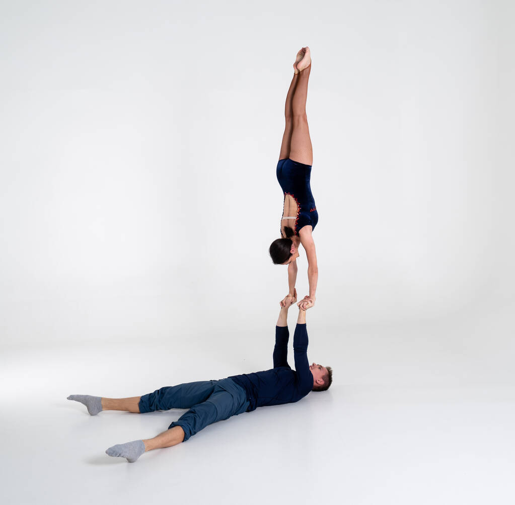 Duo van acrobaten Toont hand in hand Trick, geïsoleerd op wit - Foto, afbeelding