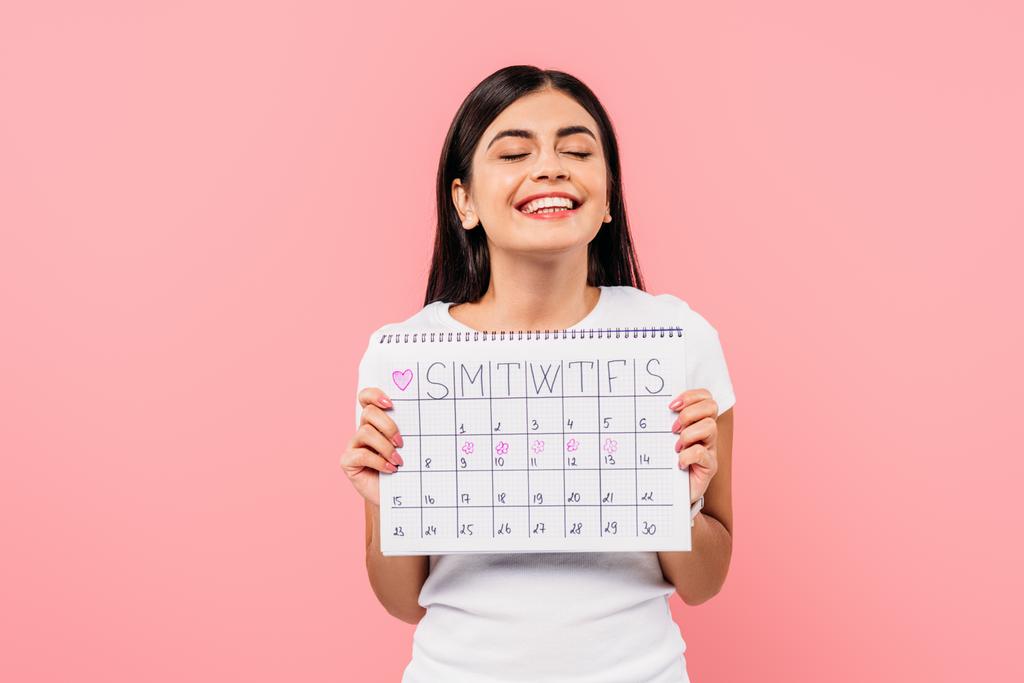 felice bella ragazza bruna tenendo il calendario periodo isolato su rosa
 - Foto, immagini