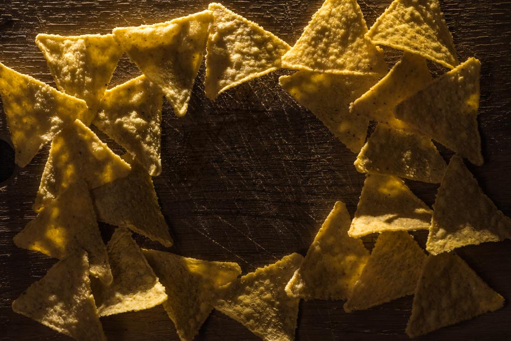 vista dall'alto di deliziosi nachos croccanti di mais disposti in cornice su tavolo rustico in legno con spazio copia
 - Foto, immagini