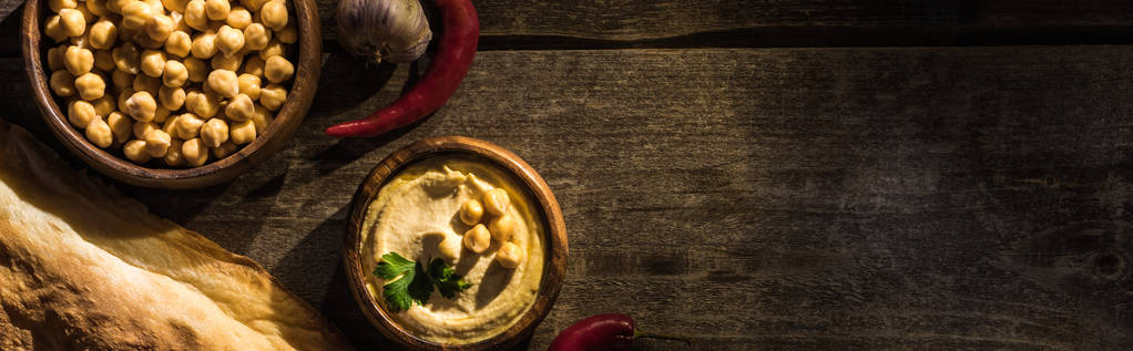 おいしいフムス、ひよこ豆、ピタ、木の素朴なテーブルの上のスパイス、パノラマショット - 写真・画像