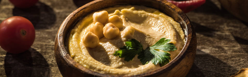 köstlicher Hummus, Kichererbsen, Kirschtomaten auf rustikalem Holztisch, Panoramaaufnahme - Foto, Bild