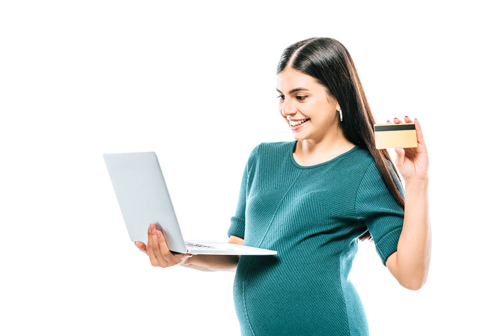mosolygós terhes lány gazdaság laptop és hitelkártya elszigetelt fehér - Fotó, kép