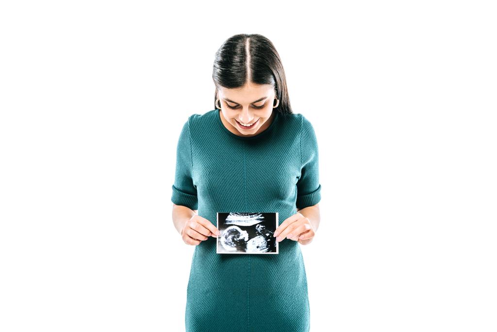 Gülen hamile bir kız beyaz üzerinde cenin ultrason görüntüsü tutuyor. - Fotoğraf, Görsel
