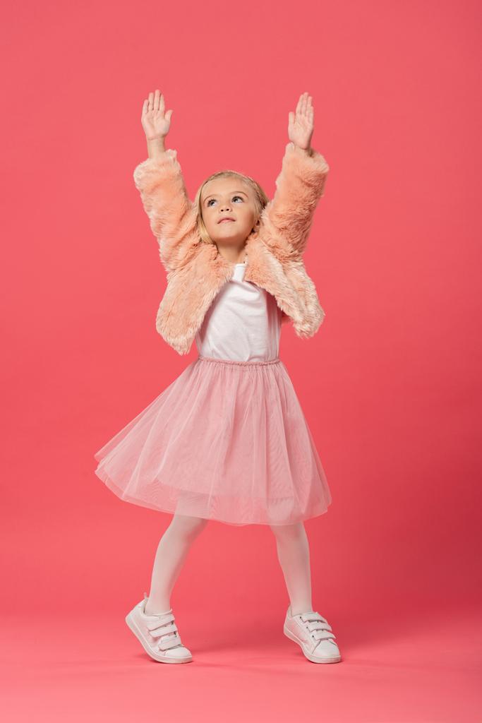 χαριτωμένο και κομψό παιδί με απλωμένα χέρια σε ροζ φόντο  - Φωτογραφία, εικόνα