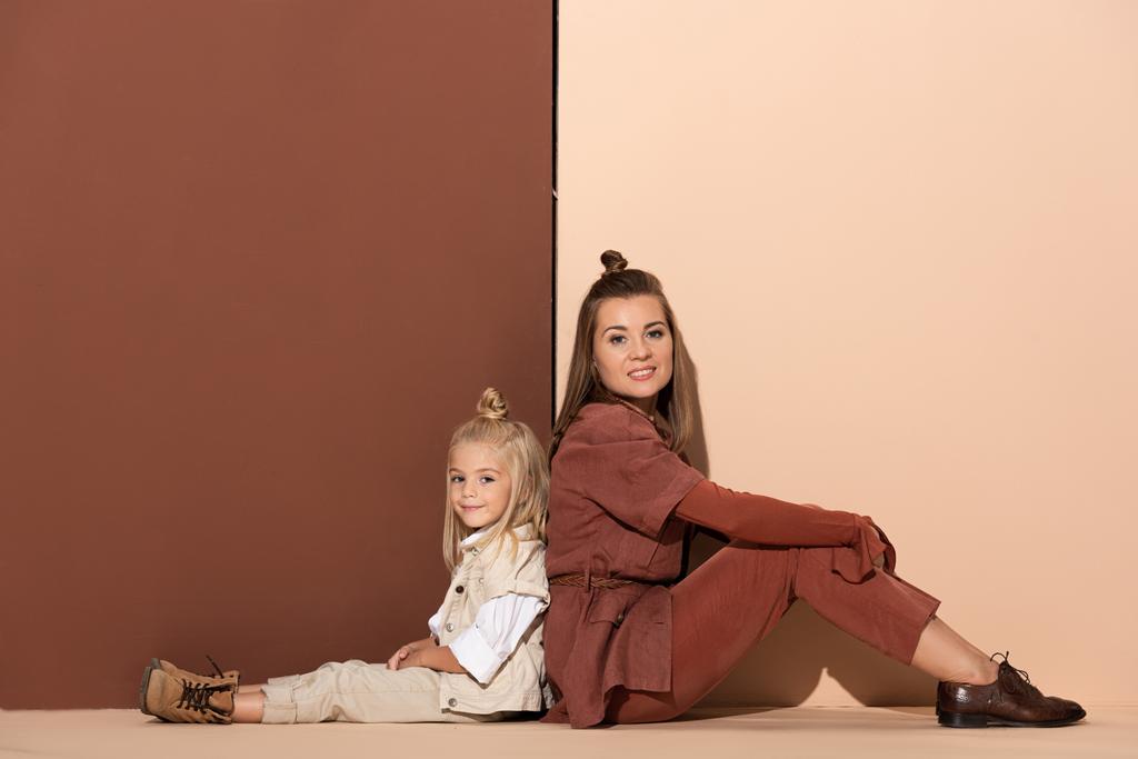 souriant fille et mère regardant caméra sur fond beige et brun
  - Photo, image