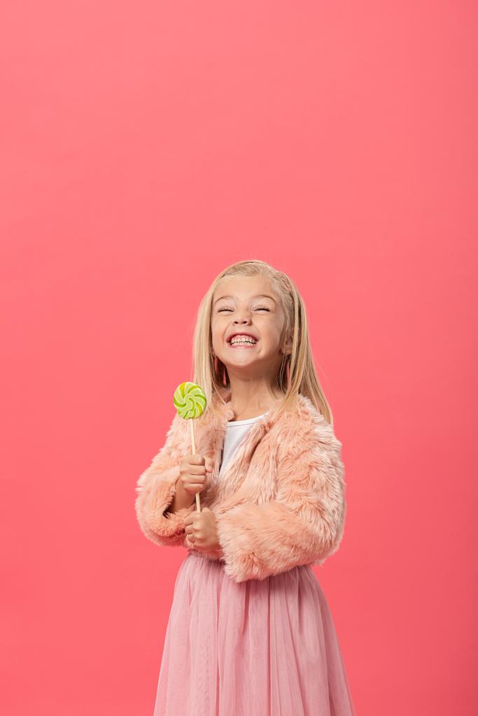 souriant et mignon enfant tenant sucette isolé sur rose
 - Photo, image