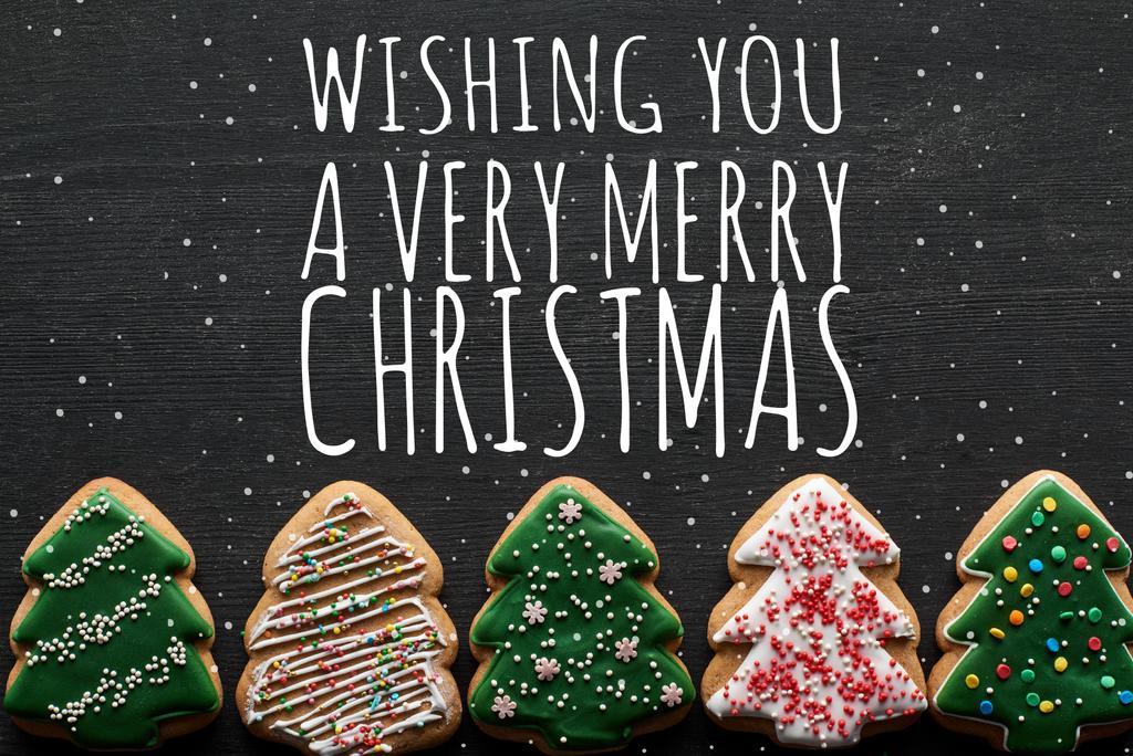 επίπεδη θέσει με νόστιμα τζάμια χριστουγεννιάτικο δέντρο cookies σε μαύρο φόντο με σας ευχόμαστε μια πολύ Καλά Χριστούγεννα εικονογράφηση - Φωτογραφία, εικόνα