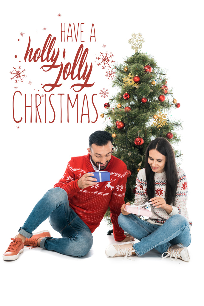 wesoły mężczyzna i szczęśliwa kobieta trzymając prezenty w pobliżu choinki odizolowany na białym z Holly wesołych ilustracji Bożego Narodzenia - Zdjęcie, obraz