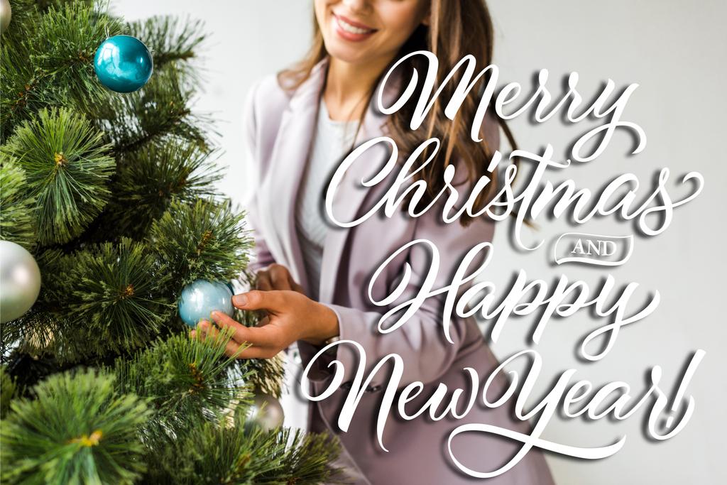 Noel ağacını mutlu noeller ve mutlu yeni yıl resimleriyle süsleyen iş kadını manzarası. - Fotoğraf, Görsel