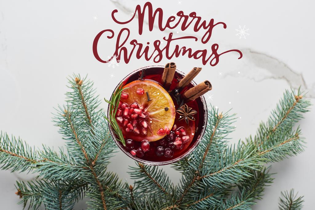 Draufsicht auf den Weihnachtscocktail mit Orange, Granatapfel, Zimt mit froher Weihnachtsillustration  - Foto, Bild