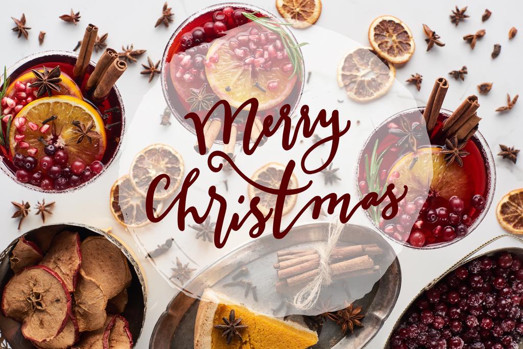 vista dall'alto di cocktail natalizi con arancia, melograno, cannella, torta su vassoio, mele secche e mirtillo rosso congelato con allegra illustrazione natalizia
  - Foto, immagini