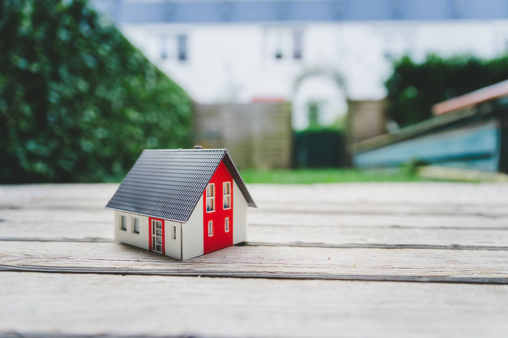 Modelo de casa roja en el suelo, al aire libre. Concepto de nuevo hogar, propiedad y patrimonio
 - Foto, Imagen