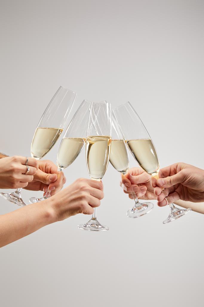 vista recortada de mujeres y hombres brindar copas de champán con vino espumoso aislado en gris
  - Foto, Imagen