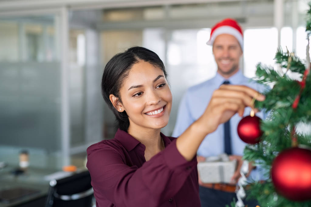 Donna d'affari decorazione albero di Natale in ufficio
 - Foto, immagini