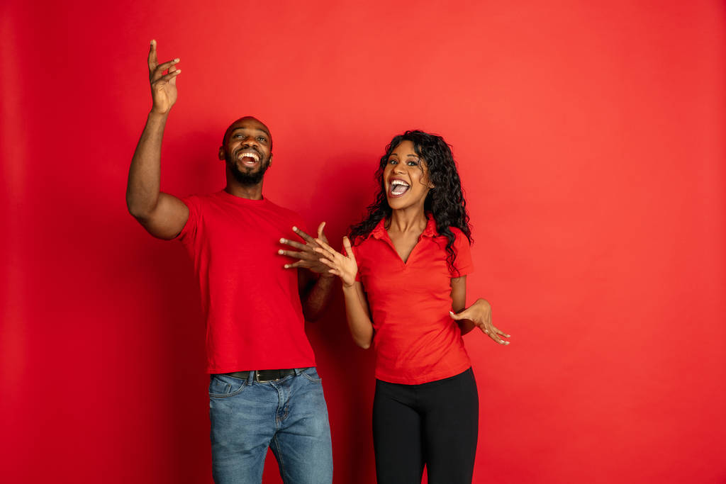Joven afro-americano emocional hombre y mujer sobre fondo rojo
 - Foto, imagen