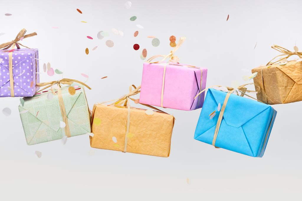 confettis tombant près de cadeaux colorés sur blanc
 - Photo, image