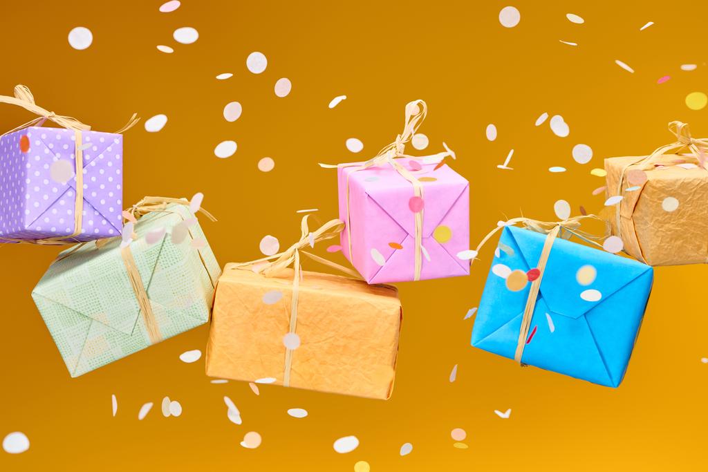 падение конфетти рядом красочные подарки на оранжевый
  - Фото, изображение