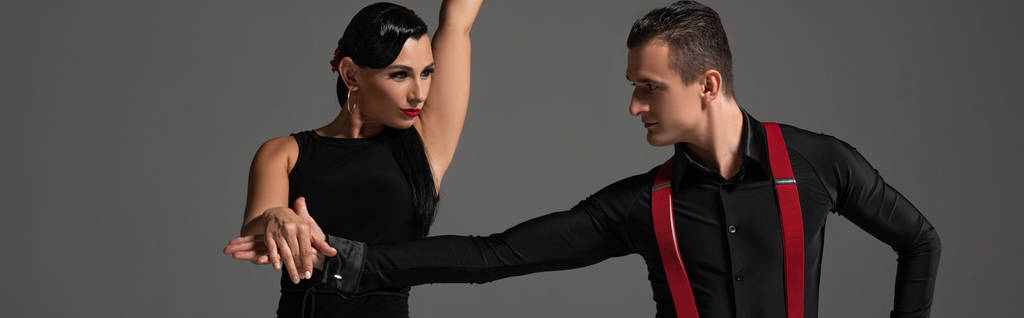 panoramatický záběr elegantních tanečníků v černém oblečení tango izolované na šedé - Fotografie, Obrázek