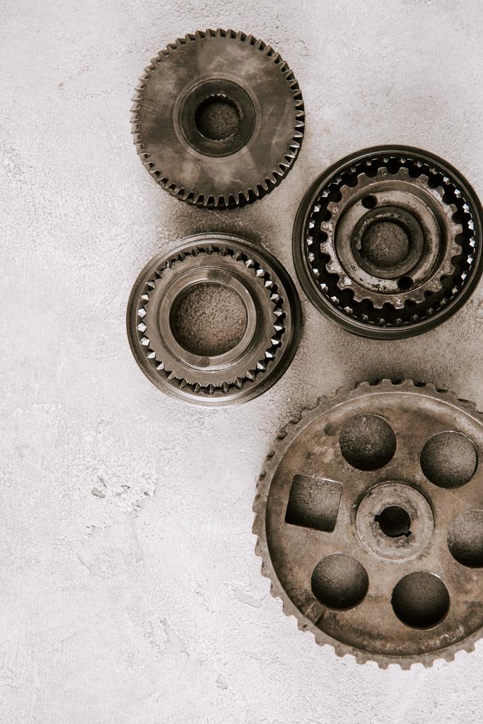 top view of aged metal round gears on grey background - 写真・画像