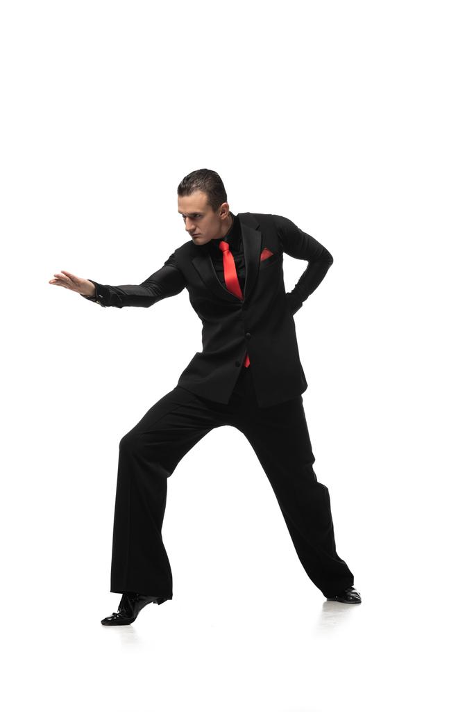 leidenschaftliche Tangotänzerin im eleganten schwarzen Anzug, der zum Tanz auf weißem Hintergrund einlädt - Foto, Bild
