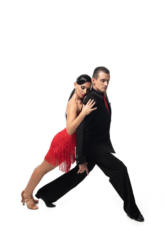 привлекательная танцовщица опирается на спину элегантного партнера во время исполнения танго на белом фоне
 - Фото, изображение