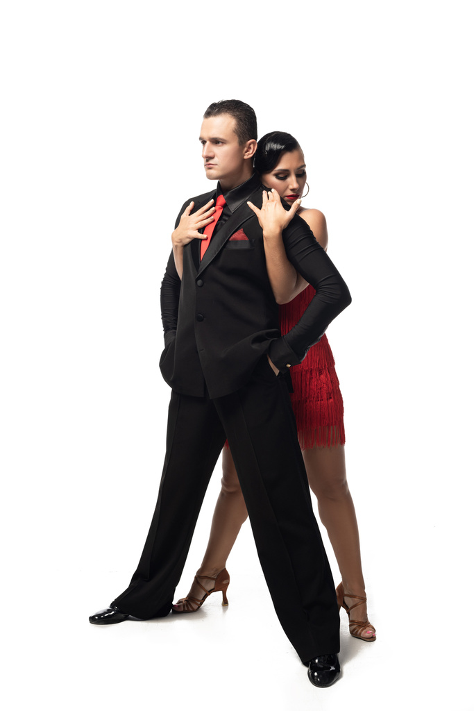 sinnliche Tänzerin umarmt gutaussehende, selbstbewusste Partnerin von hinten, während sie Tango auf weißem Hintergrund aufführt - Foto, Bild