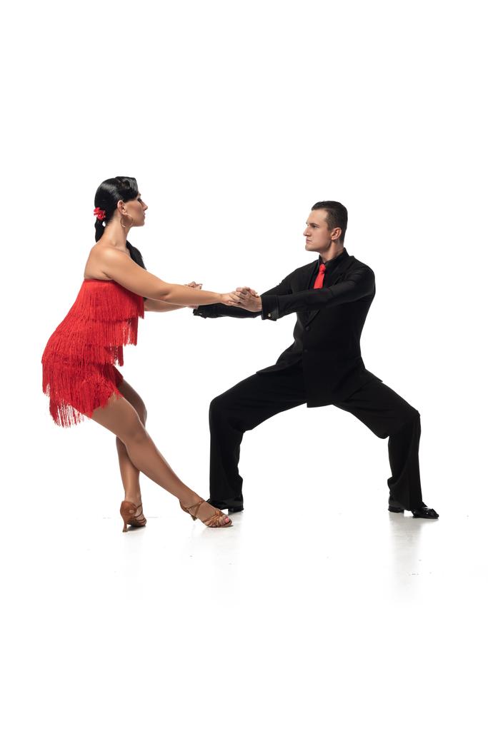 graceful, elegant dancers looking at each other while performing tango on white background - Photo, Image