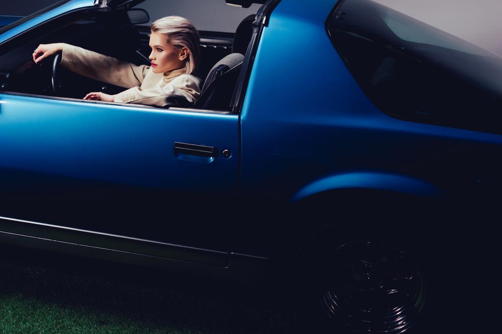 korkea kulma näkymä houkutteleva ja tyylikäs nainen puku istuu retro auto
  - Valokuva, kuva