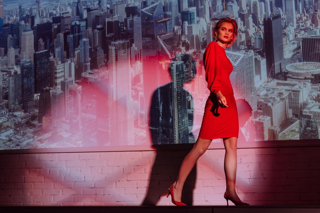 attraktive und stilvolle Frau in rotem Kleid auf Stadthintergrund  - Foto, Bild