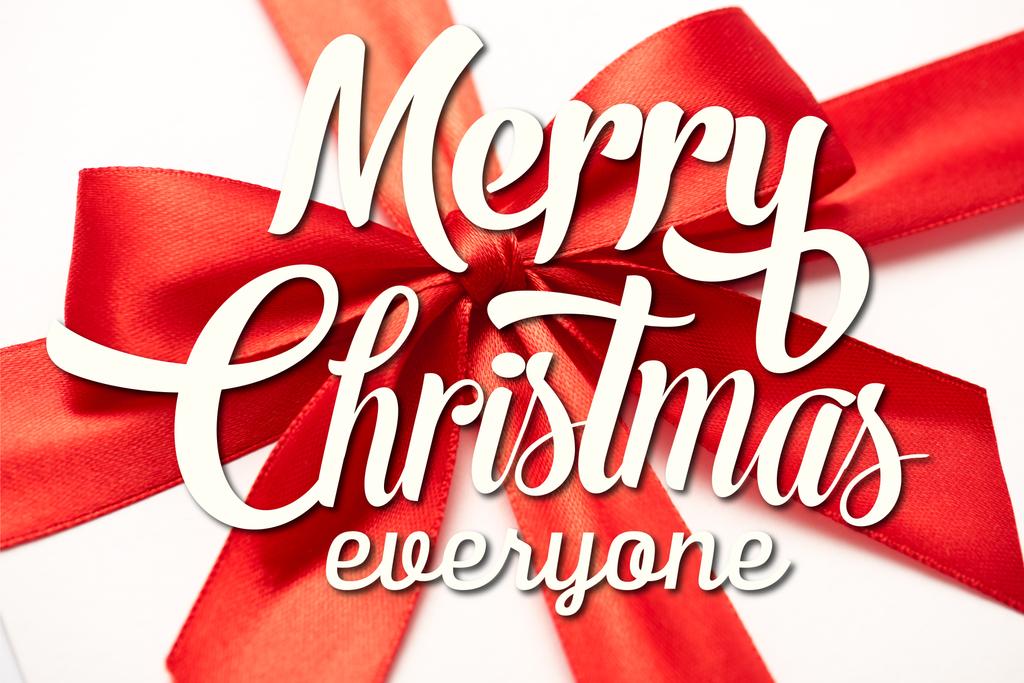 primer plano de cinta de satén con lazo rojo decorativo con feliz Navidad todo el mundo letras en blanco
  - Foto, Imagen