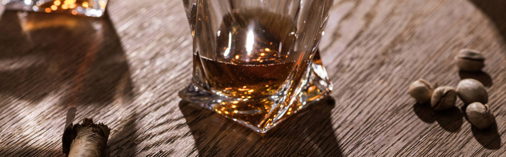 Panoramatický záběr brandy, doutníku a pistácií na dřevěném stole - Fotografie, Obrázek