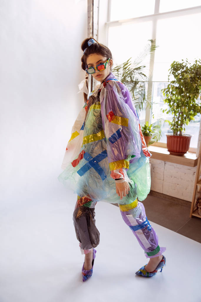 Woman addicted of sales and clothes, wearing plastic, recycling concept - 写真・画像
