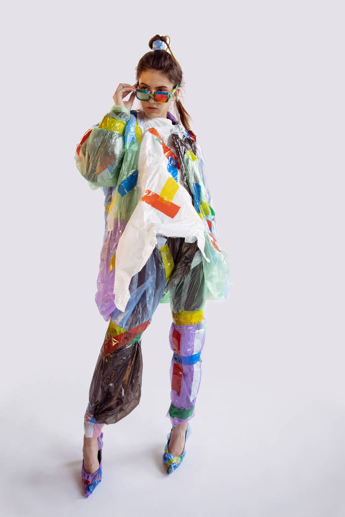 Mulher viciada em vendas e roupas, vestindo plástico, conceito de reciclagem
 - Foto, Imagem
